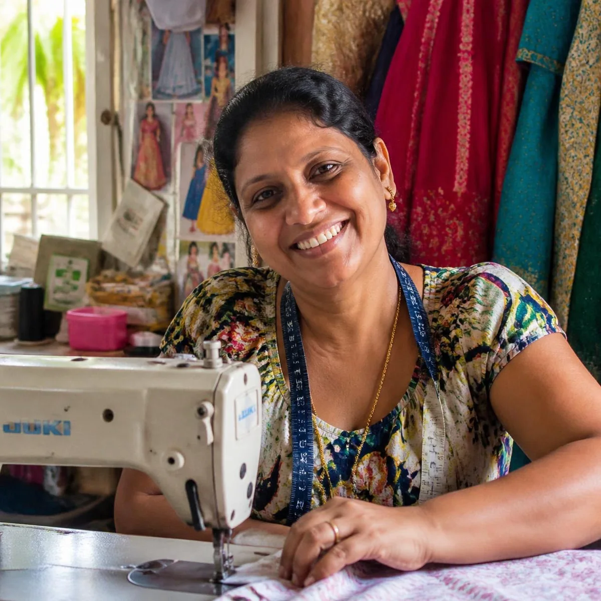 A dressmaker smiling at her sewing machine